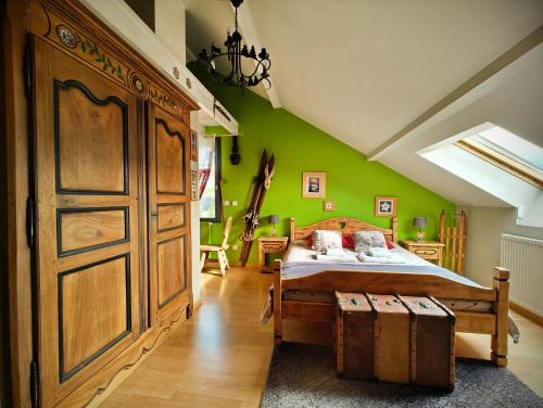 a bedroom with a bed and a green wall at Le Belvédère : chambres et table d'hôtes in Montmélian