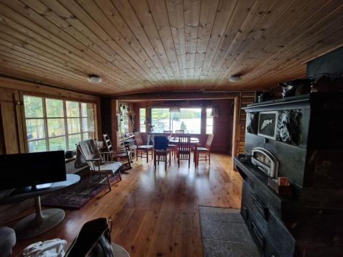 sala de estar con mesa y sillas y sala de estar con en Kuikkoniemi- A Lake view cabin with hot tub n more, en Mikkeli