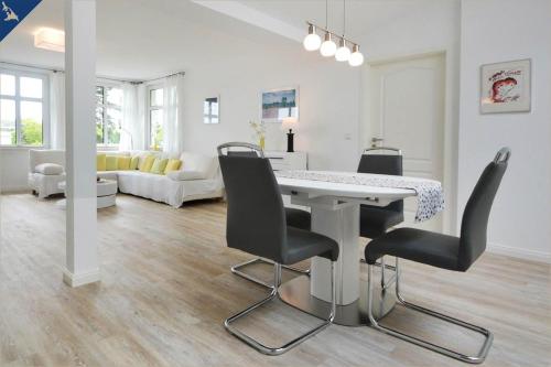 uma sala de estar branca com uma mesa e cadeiras em Apartment Martha 1 em Heringsdorf