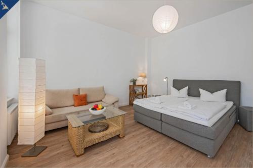 een woonkamer met een bed en een bank bij Apartment Martha 2 in Heringsdorf