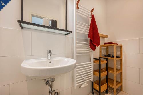 een badkamer met een witte wastafel en een plank bij Apartment Martha 2 in Heringsdorf