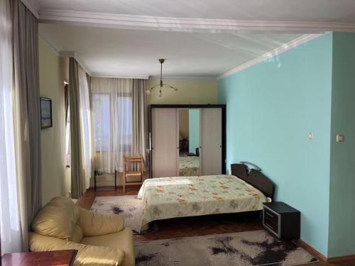 - une chambre avec un lit et un canapé dans l'établissement При Bond-100 м/2 със градина, à Bourgas
