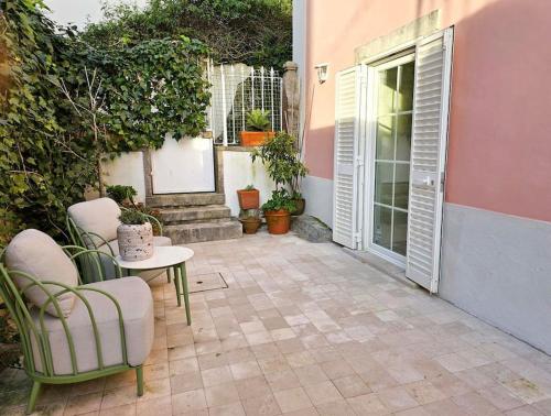 a patio with chairs and a table and a door at Depósito in Sintra