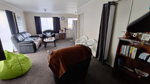 a living room with a couch and a chair at Bowmont in Invercargill