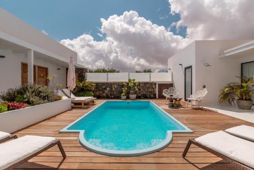 a swimming pool on a deck with a house at Villa Shepherd Lajares - LUXURY VILLA FUERTEVENTURA in Lajares
