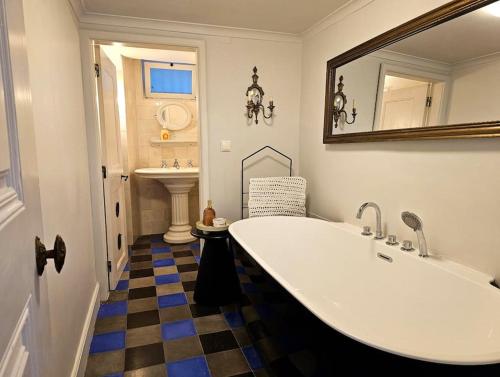 uma casa de banho com uma grande banheira branca e um piso em xadrez em Fantastic Sintra! em Sintra