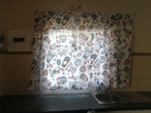 a window with a curtain with drawings on it at GLORIA'S GUESTS.COM in Polokwane