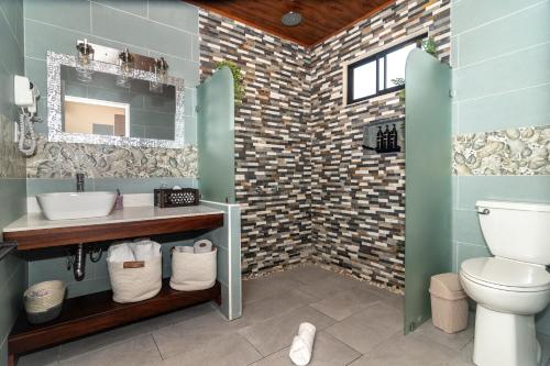 a bathroom with a sink and a toilet at House Monstera Arenal in Agua Azul