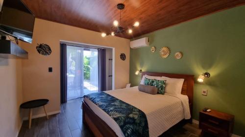 a bedroom with a bed in a room with green walls at House Monstera Arenal in Agua Azul