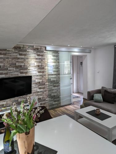a living room with a brick wall at Ferienwohnung Zum Kühlen Grund in Eimelrod