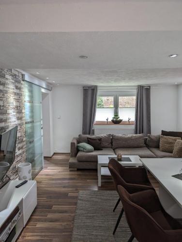 a living room with a couch and a tv at Ferienwohnung Zum Kühlen Grund in Eimelrod
