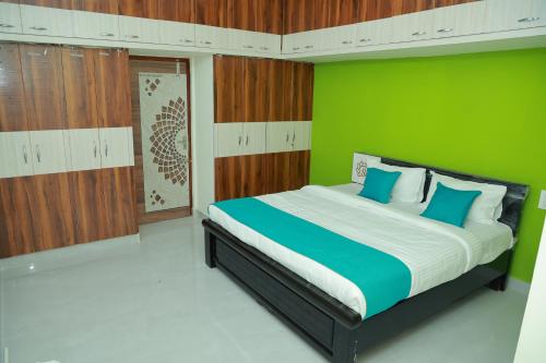 a bedroom with a large bed with a green wall at Sun Home Stays - Spacious Rooms - New Property - Pleasant Location in Tirupati