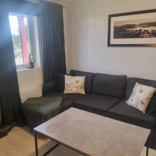 un soggiorno con divano e tavolo di Apartment near center / free P ad Ålesund