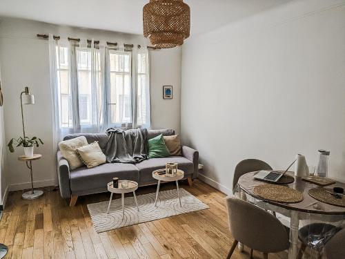 een woonkamer met een bank en een tafel bij HbyB - 1BR - Coeur Boulogne in Boulogne-Billancourt