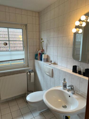 a white bathroom with a sink and a toilet at Haus - Meeresbrise in Lancken-Granitz