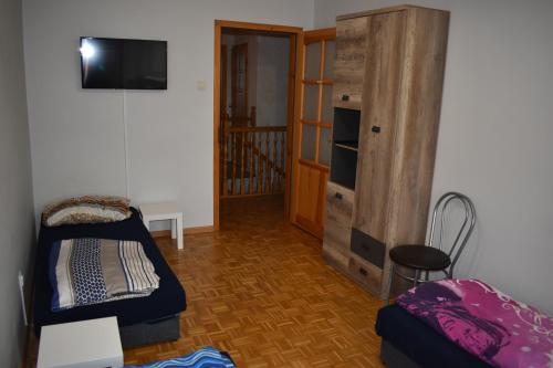 a room with a bunk bed and a wooden cabinet at Pokoje Jasionka Zaczernie in Trzebownisko