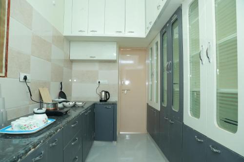 a kitchen with gray cabinets and a counter top at Sun Home Stays - Spacious Rooms - New Property - Pleasant Location in Tirupati