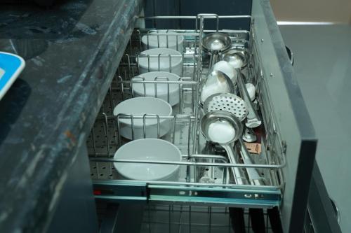 a dish drying rack filled with dishes and utensils at Sun Home Stays - Spacious Rooms - New Property - Pleasant Location in Tirupati