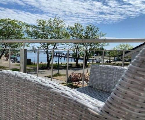 einen Korbstuhl auf einer Veranda in der Unterkunft Ferienhaus Am Hafen 11 Altwarp mit Sauna, Kamin und Wasserblick in Altwarp