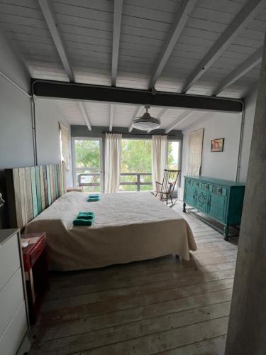 a bedroom with a bed and a table and window at El Cerezzo in Puerto Pirámides