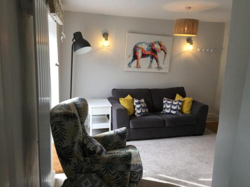 a living room with a couch and a chair at The Burrow in Wetherby