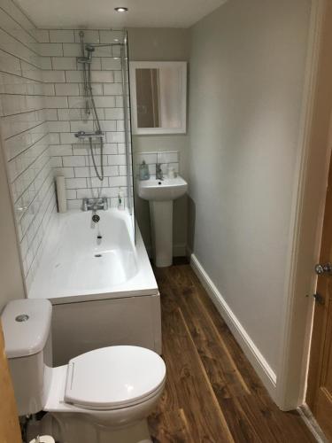 a bathroom with a toilet and a tub and a sink at The Burrow in Wetherby