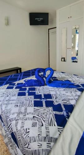 Una cama con una manta azul y blanca. en Sunny Room in Habitat, en Maspalomas