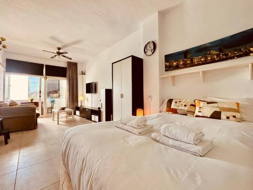 um quarto com uma cama branca e toalhas em Click&Guest - El Mirador de la Puntilla em Las Palmas de Gran Canaria