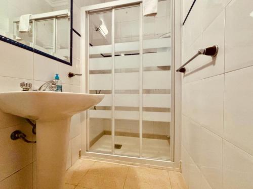uma casa de banho com um lavatório e uma cabina de duche em vidro. em Click&Guest - El Mirador de la Puntilla em Las Palmas de Gran Canaria