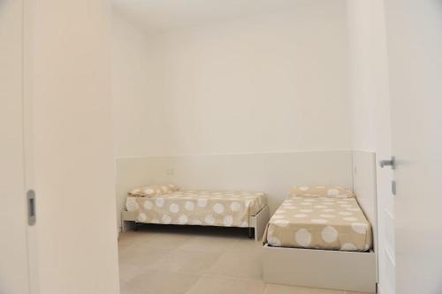 Habitación blanca con 2 camas y puerta en Appartamento Bartolomeo Colleoni, en Cavernago