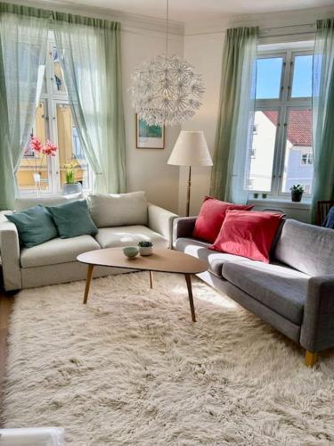 a living room with two couches and a coffee table at Sentralt og romslig i Kristiansand sentrum in Kristiansand
