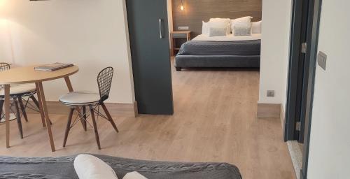 a bedroom with a bed and a table and chairs at Hotel Sercotel Cuatro Postes in Avila