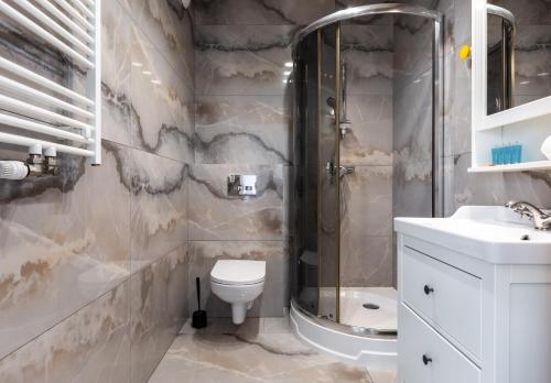 La salle de bains est pourvue d'une douche, de toilettes et d'un lavabo. dans l'établissement Marina Gdańsk Cosy Studio, à Gdańsk
