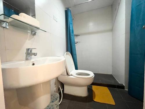 y baño con aseo blanco y lavamanos. en KL Tower Studio Near Greenbelt Makati, en Manila
