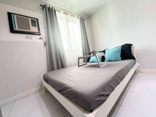 1 dormitorio con 1 cama y aire acondicionado en KL Tower Studio Near Greenbelt Makati, en Manila