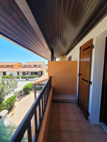 a balcony with a door and a view of a courtyard at Villa 6p piscine spa privatif wifi proche des plages in Le Barcarès