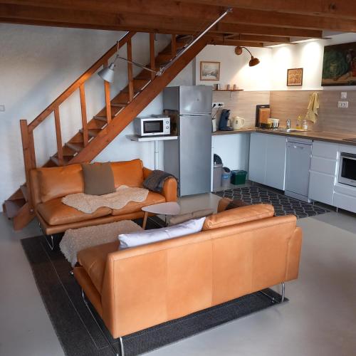 un salon avec un canapé et une cuisine dans l'établissement La Petite Bellarderie, à Champniers