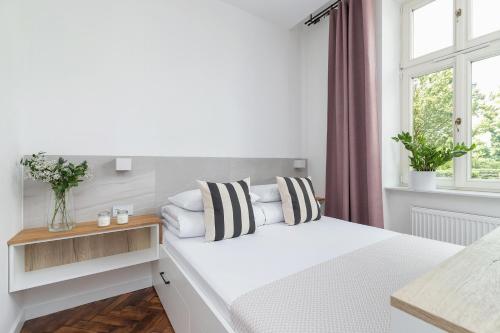um quarto branco com uma cama e uma janela em Kazimierz District - Dietla 21 - Studio Apartment em Cracóvia