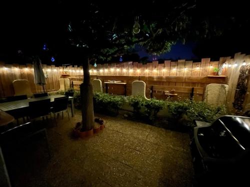 un patio con una mesa y un árbol por la noche en Villa T3 6 couchages - Piscine-WIFI-Garage en Saint-Cyprien