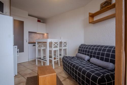un salon avec un canapé et une cuisine dans l'établissement Studio de la Trafolée - Welkeys, à Huez