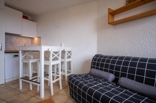 un salon avec un canapé et une cuisine dans l'établissement Studio de la Trafolée - Welkeys, à Huez