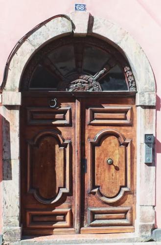 une grande porte en bois avec une arche dans un bâtiment dans l'établissement Studio centre historique Thonon, à Thonon-les-Bains
