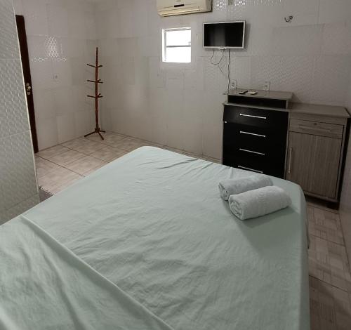 a large white bed in a room with a kitchen at Pousada Santo Amaro in Juazeiro do Norte