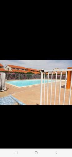 a view of a swimming pool with a white railing at Villa 6p piscine spa privatif wifi proche des plages in Le Barcarès