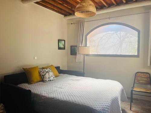 - une chambre avec un lit, une fenêtre et une chaise dans l'établissement T1 Au pied du Garlaban 30 minutes de Cassis, à Roquevaire