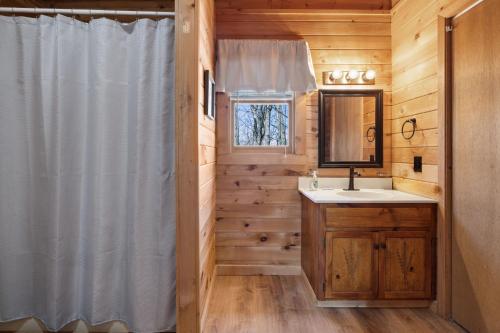 a bathroom with a shower curtain and a sink at Updated family friendly Cabin, hot tub, near Gatlinburg, Pigeon Forge, Dollywood in Sevierville
