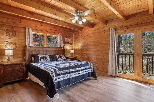 a bedroom with a bed in a log cabin at Updated family friendly Cabin, hot tub, near Gatlinburg, Pigeon Forge, Dollywood in Sevierville