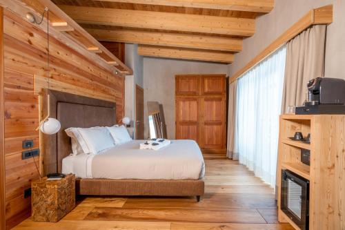 a bedroom with a bed and a fireplace at Au Charmant Petit Lac - Ecohotel Parc & Spa in Champoluc