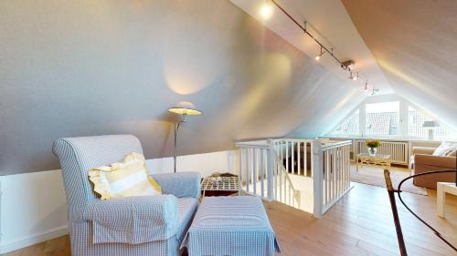 a living room with blue chairs and a staircase at Lee Biberhüs in Archsum