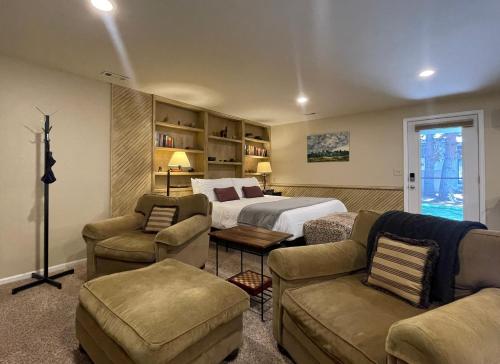 a hotel room with a bed and a couch and chairs at Couples Retreat with Hot Tub, Sauna and Steam Room in Fort Collins